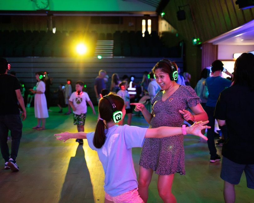 Mother and daughter dancing wearing headphones